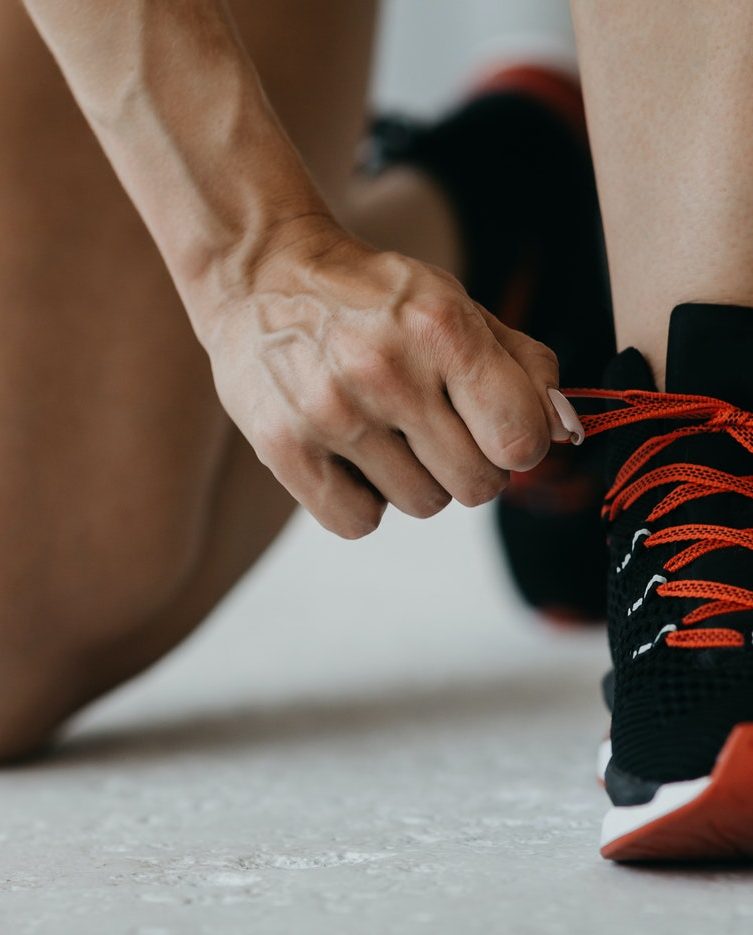 fitness-lifestyle-muscular-woman-with-smart-watch-tying-shoelaces-on-sneakers-on-gym-or-living-room.jpg